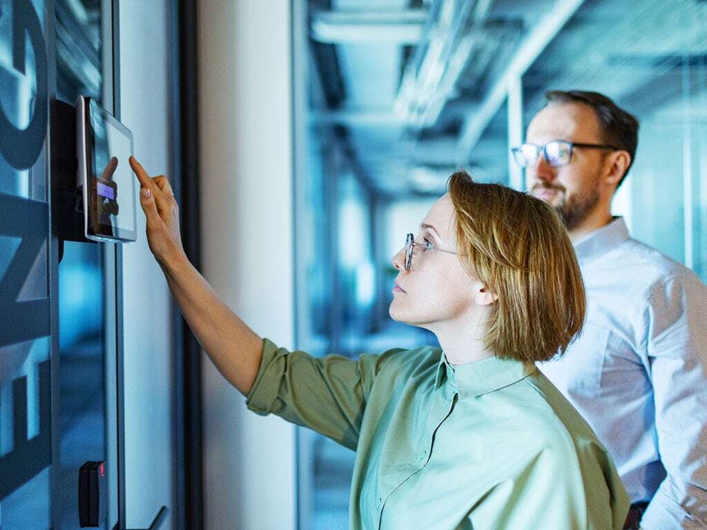 Zwei Personen im Büro mit einen Zutrittsterminal; © iStock JulPo 2168379122