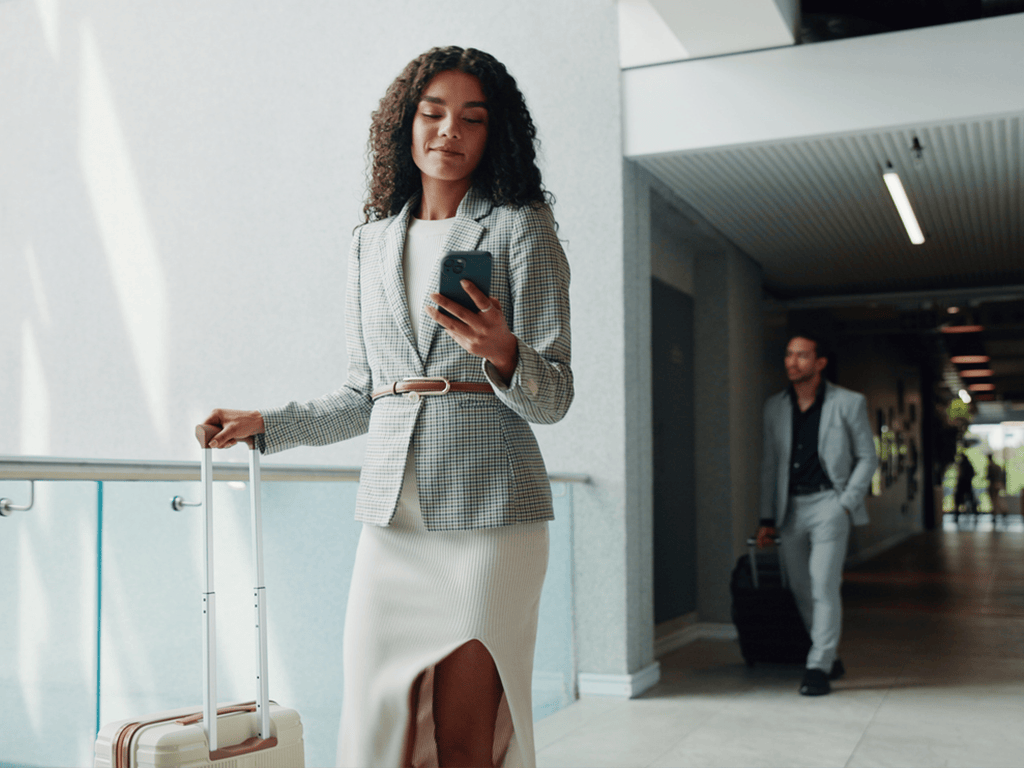 Business-Frau auf der Arbeit mit einem Koffer und Smartphone; © Jacob Wackerhausen, 2221643506