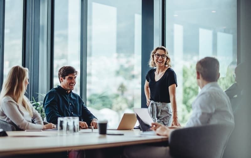 Vier Personen sitzen bei einem Meeting zusammen am Tisch