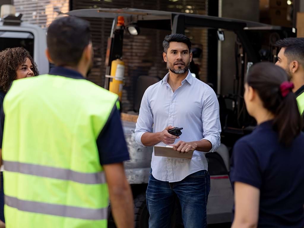 Gruppe an Logistikmitarbeitern bei einer Besprechung; © iStock 1472189905